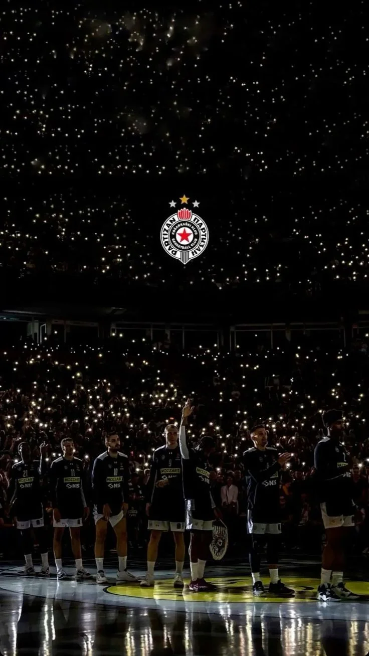 Players lined up on court while thousands of fans light up the dark arena with their phone torches