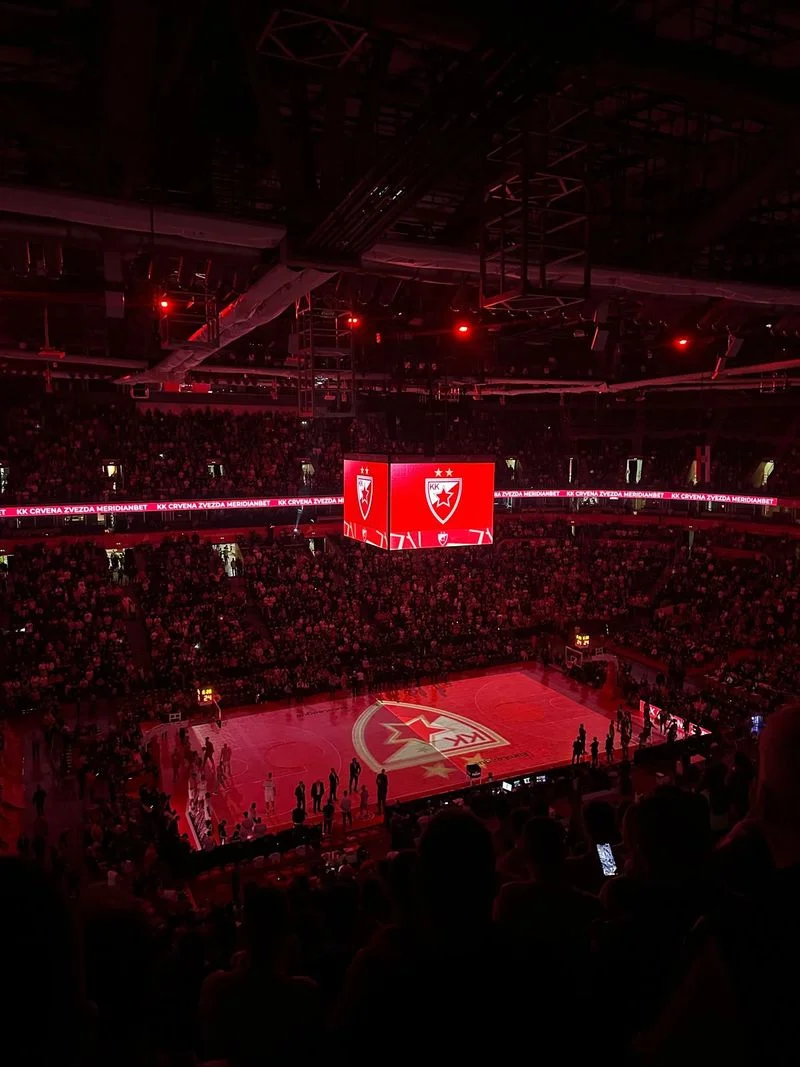 Arena bathed in red light with the home club's logo projected on the court before tip-off